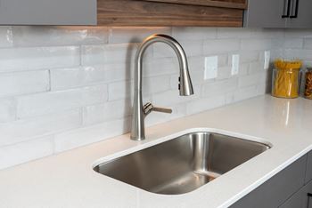 a kitchen sink with a chrome faucet on a counter top